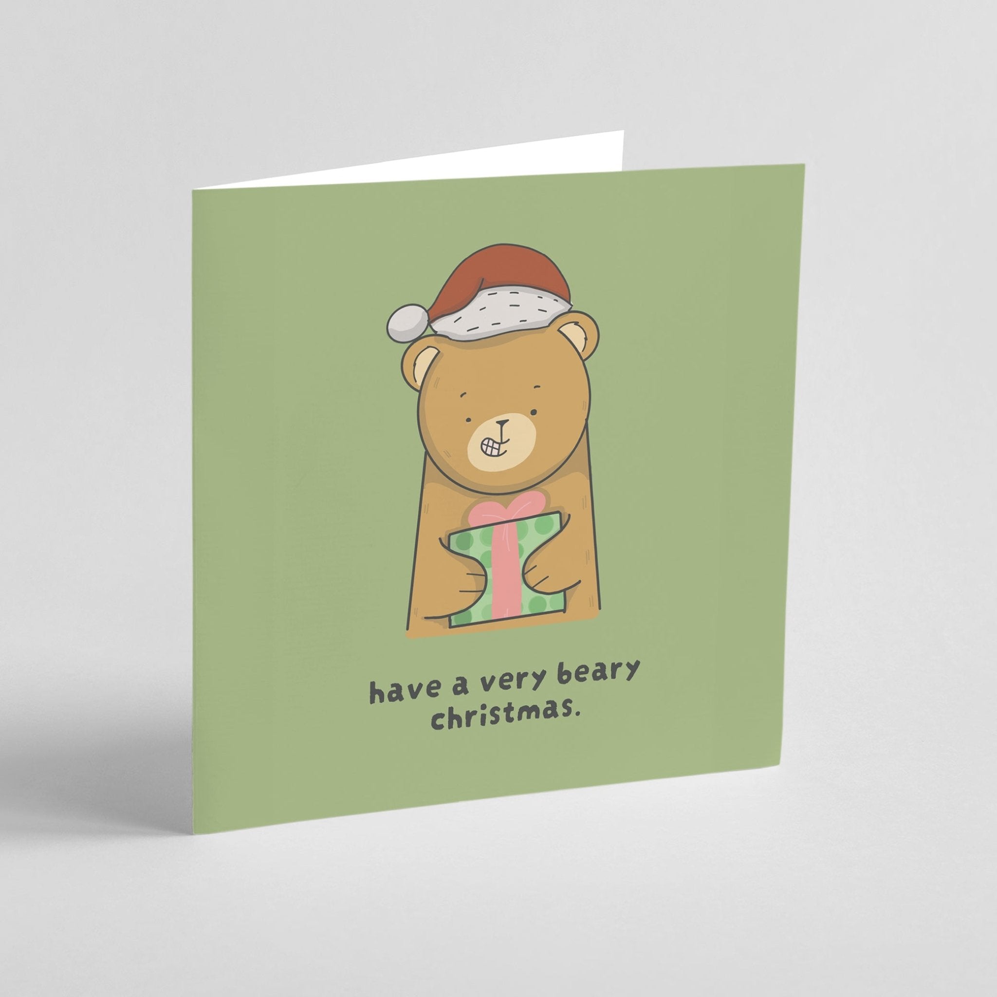 Christmas card with a bear holding a gift and text 'have a very beary christmas' on a green background