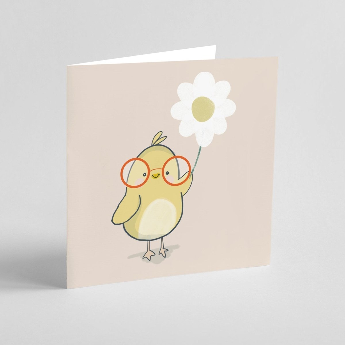 Card with a chick wearing glasses holding a flower on a beige/brown background