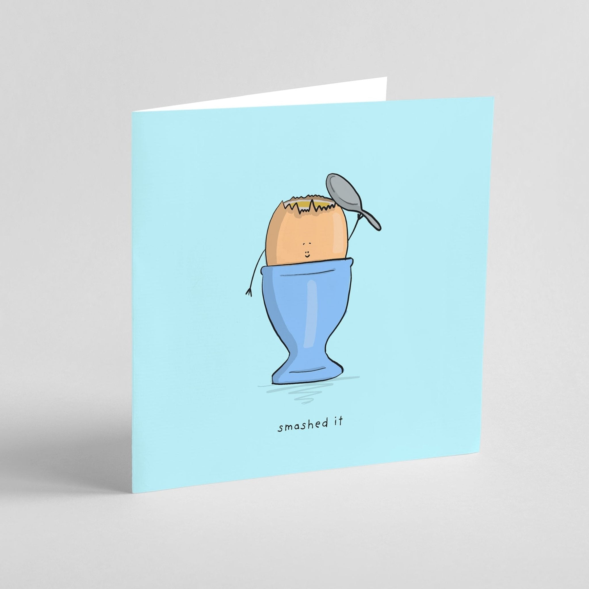 Greeting card with an illustration of a smashed egg in a blue cup on a light blue background