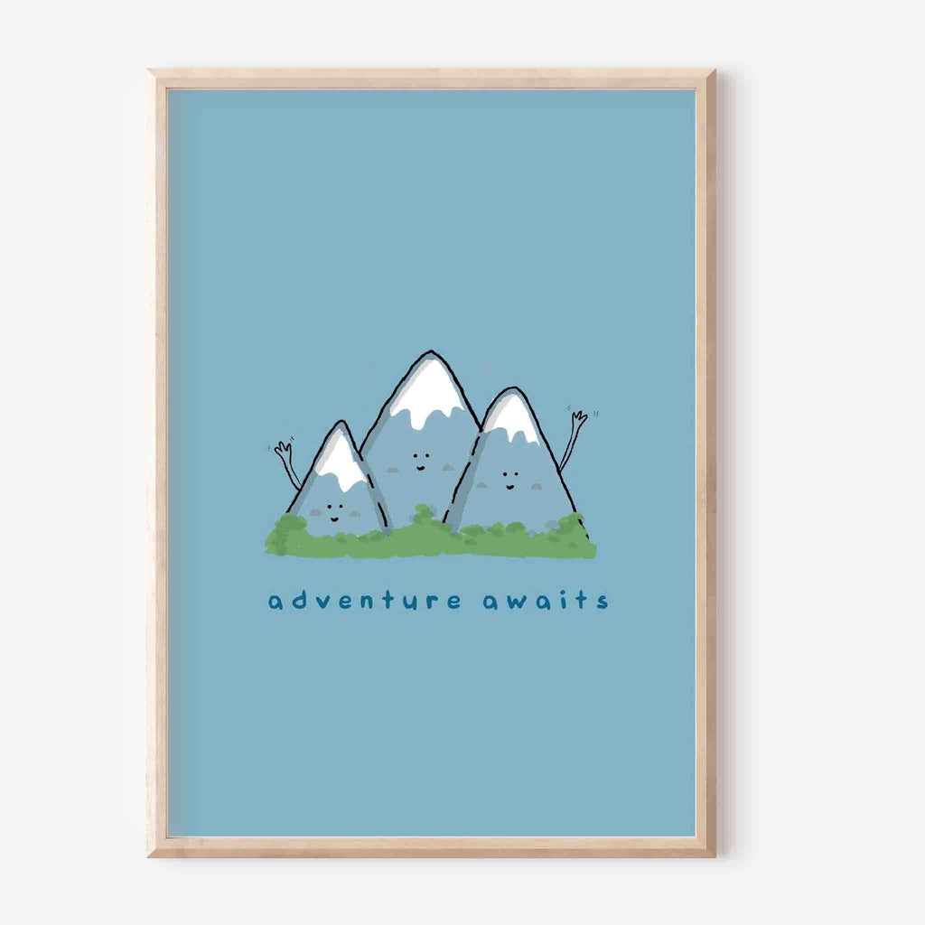 Whimsical illustrated art print featuring three smiling mountains with 'Adventure Awaits' text, framed in light wood against a serene sky blue background, perfect for nursery or home office decor.