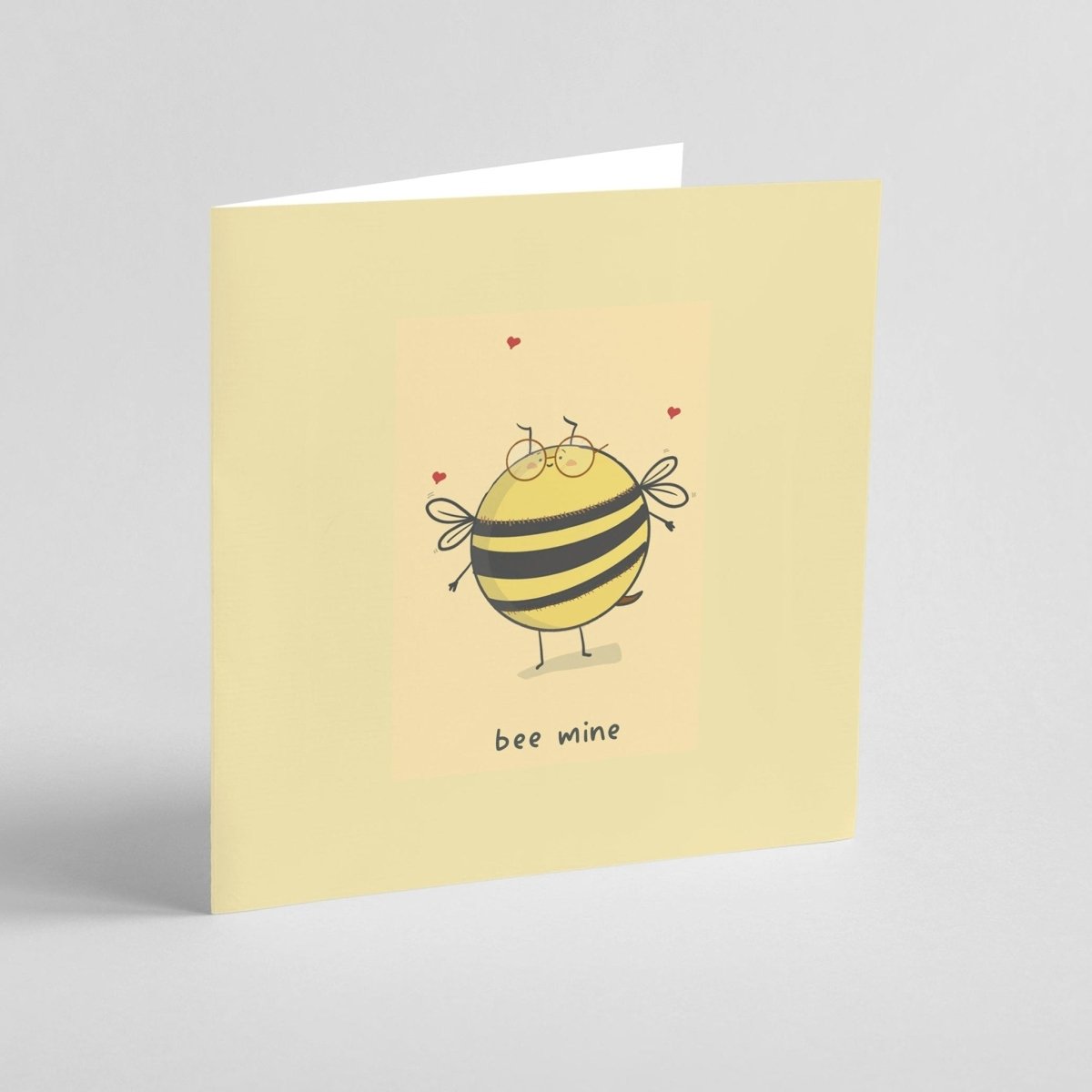Greeting card with a bee illustration and 'bee mine' text on a light yellow background