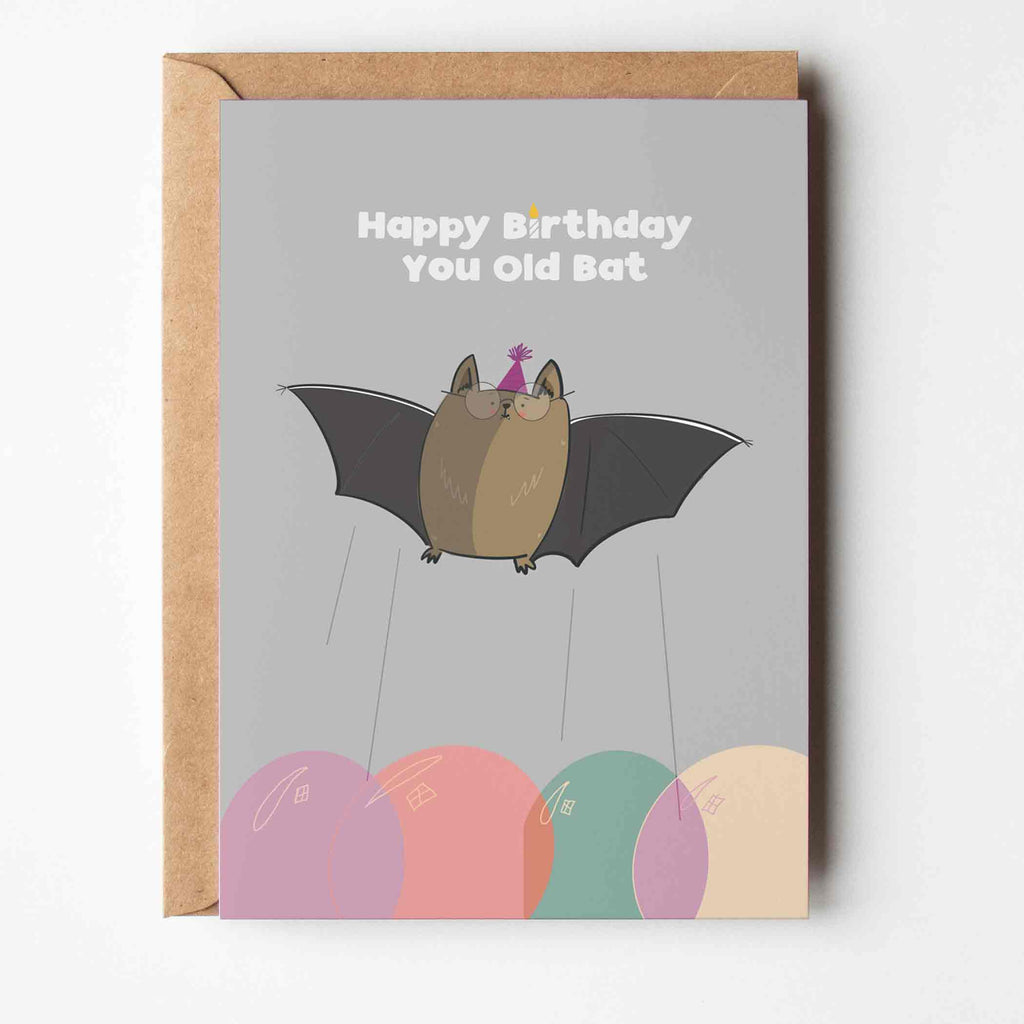 Hand-drawn 'Happy Birthday, You Old Bat' card with a cute bat wearing glasses and surrounded by vibrant balloons, ideal for a humorous birthday greeting."