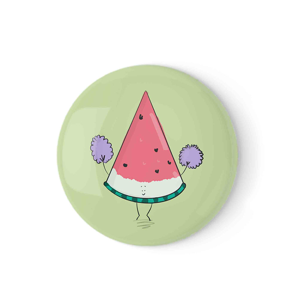 Button badge with an adorable illustrated watermelon slice with pompoms on a light green background." 