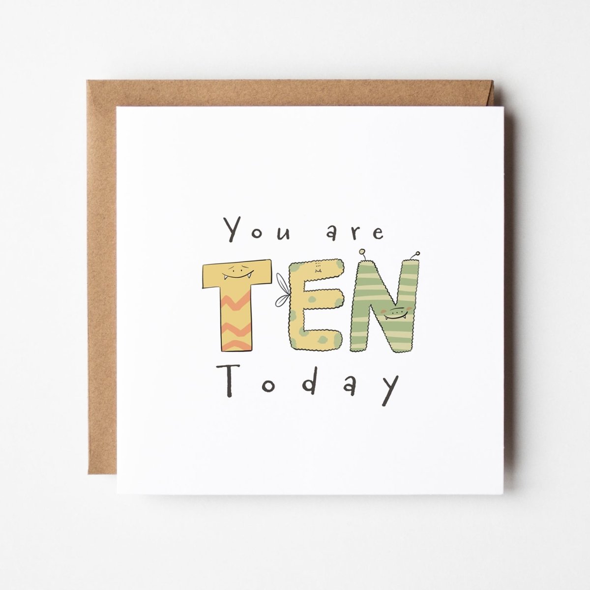 Cute monster milestone birthday card mockup showing TEN spelled with adorable monster characters