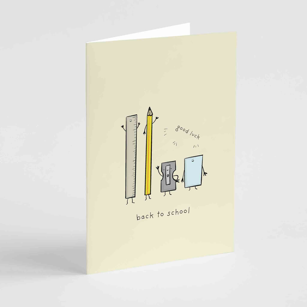 A greeting card with a whimsical illustration of animated school supplies, including a ruler, two pencils, and a piece of paper, with the words "good luck" and "back to school" on a pale background.