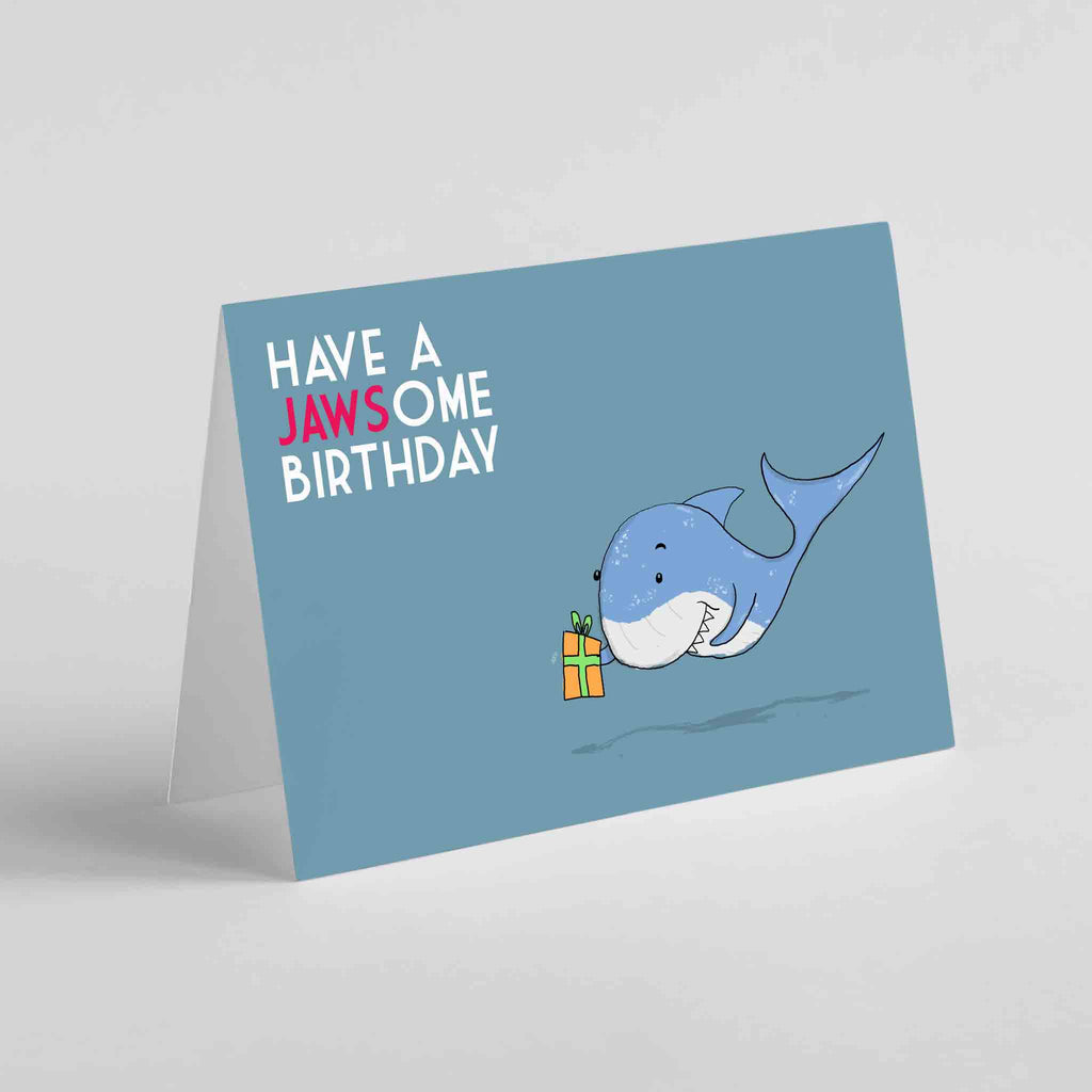 Cheerful 'Have a Jawsome Birthday' greeting card with a playful shark illustration and humorous pun, perfect for making birthdays memorable and fun.