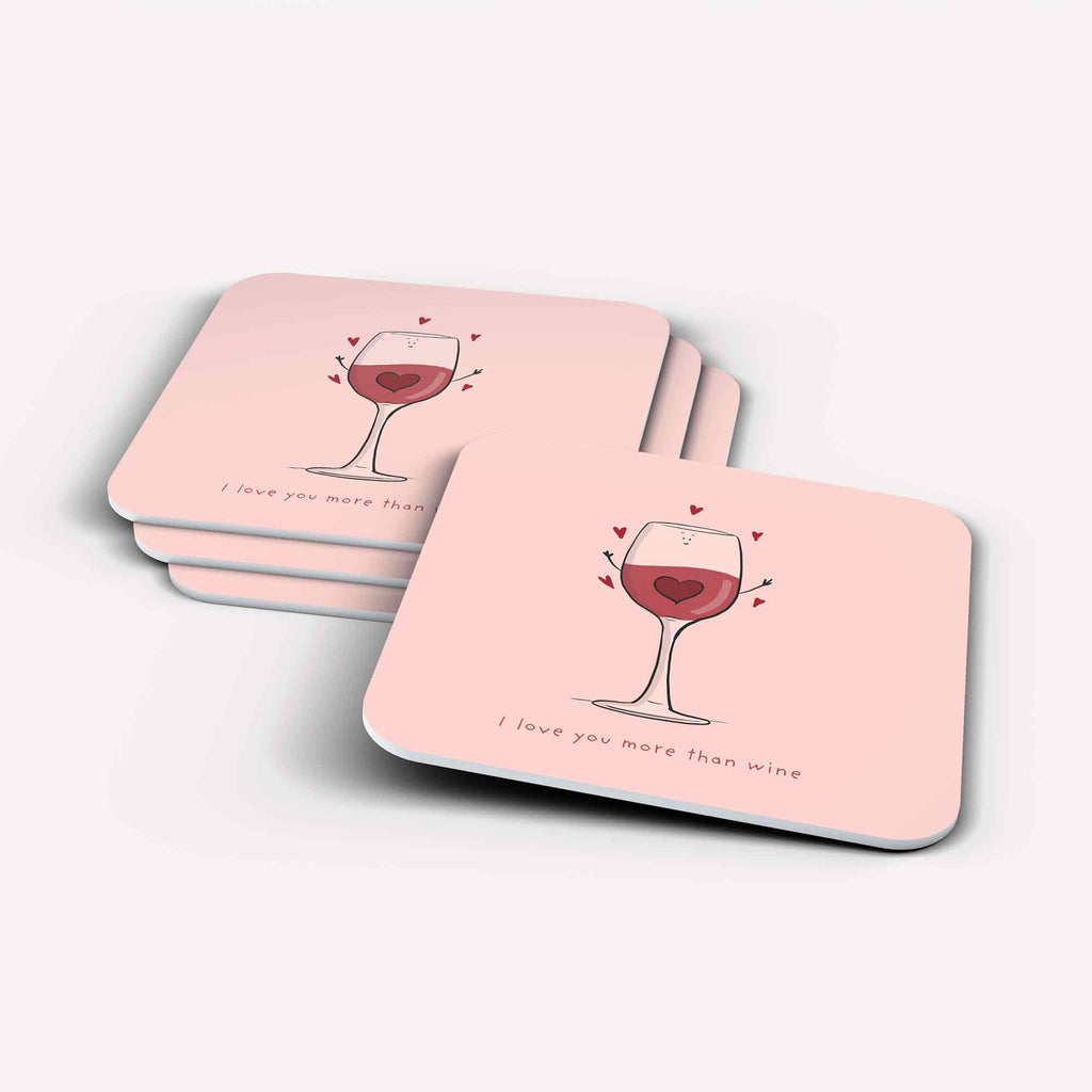 A Stack of pink square coasters with rounded corners, each featuring a wine glass with a heart inside and small hearts above, with the quote ‘I love you more than wine’.”