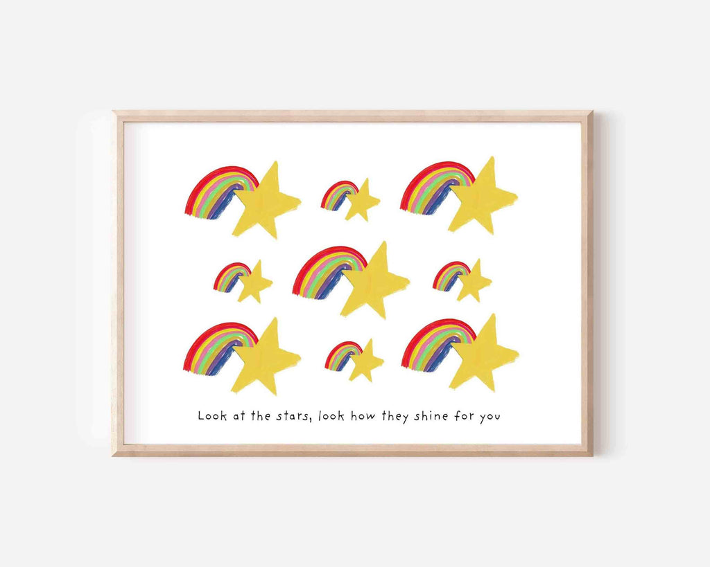Art print featuring golden stars and colorful rainbows with the quote 'Look at the stars, look how they shine for you' in a light wood frame.